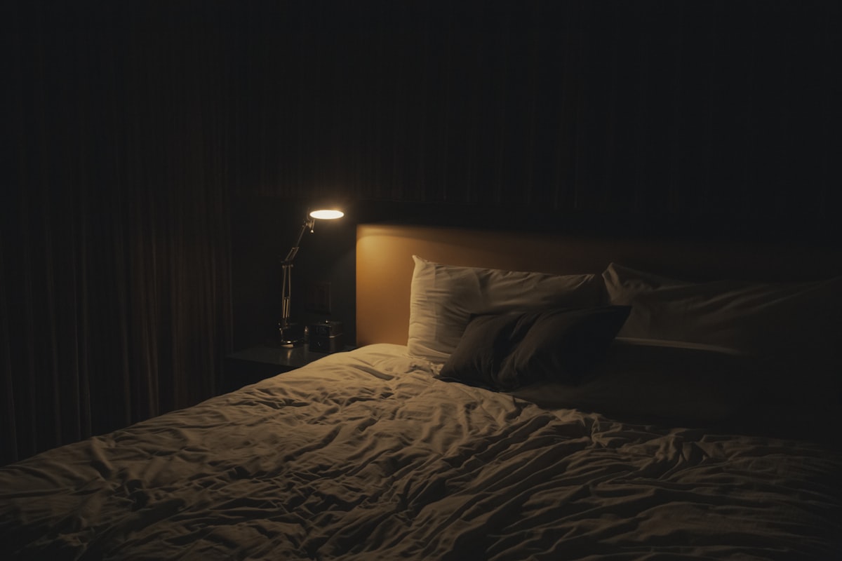 A sleep tracker on a bedside table next to a glass of water