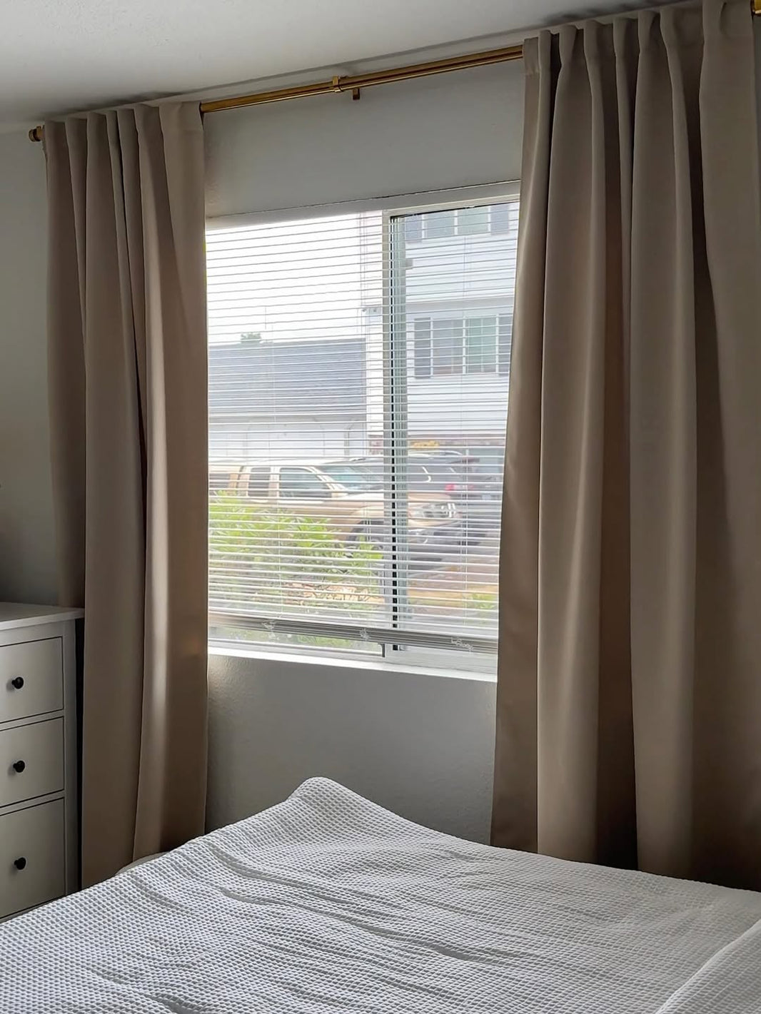 A bedroom with light leaking through curtain edges at night