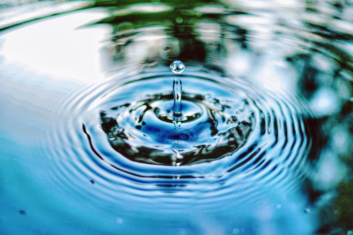 A glass of tap water being tested at a kitchen counter